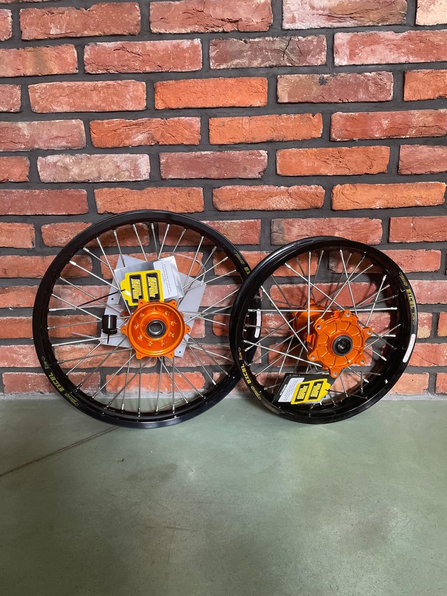 Two KTM 950 wheels with black Excel rims and orange hubs