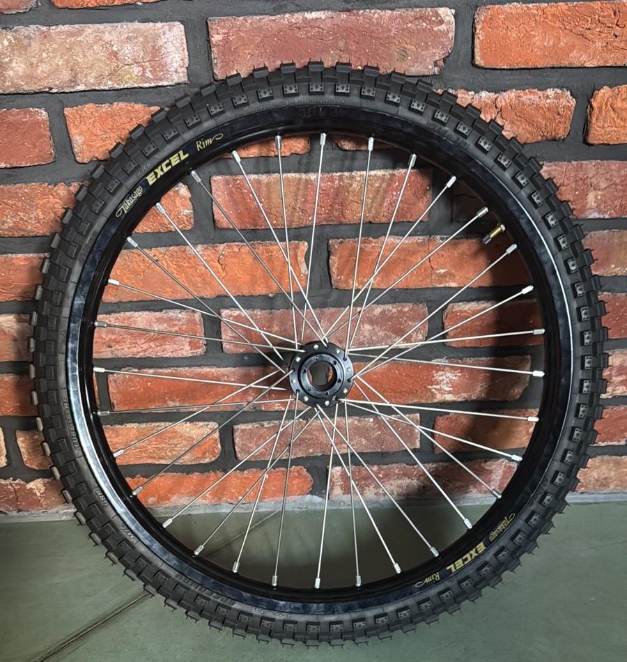 23-inch electric motorcycle wheel with a black Excel rim and an off-road tyre